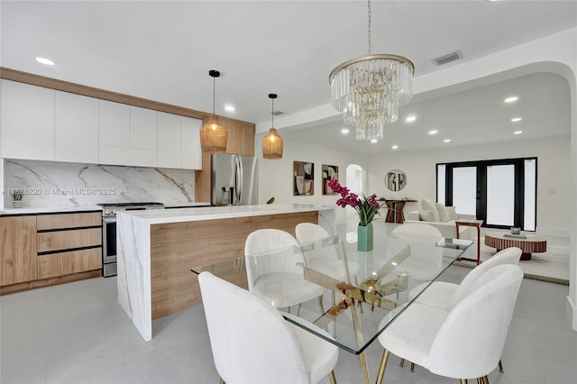 5850 Rose Ter, Plantation, FL 33317 - dining area featuring recessed lighting, arched walkways, a chandelier, concrete flooring, and french doors