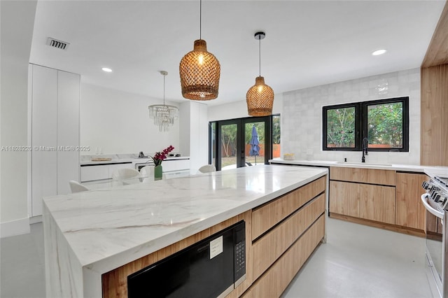 5850 Rose Ter, Plantation, FL 33317 - kitchen with french doors, stainless steel range oven, light stone counters, modern cabinets, and pendant lighting