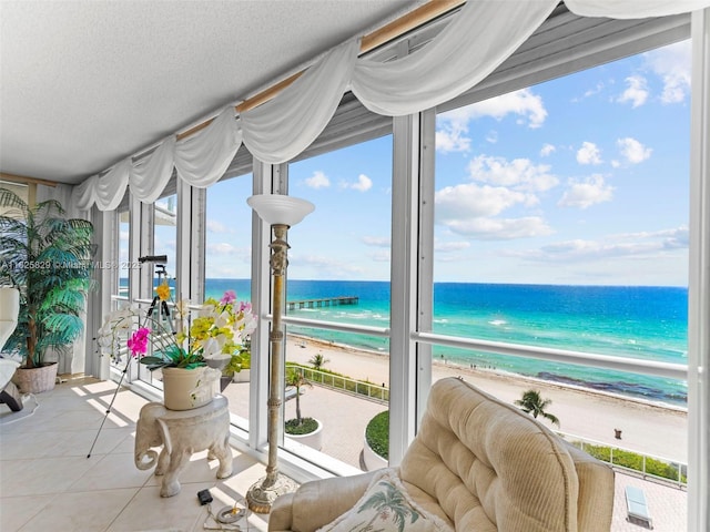 16445 Collins Ave Unit 726, Sunny Isles Beach, FL 33160 - sunroom / solarium with view of water and beach, tile patterned flooring, healthy amount of natural light, and a textured ceiling