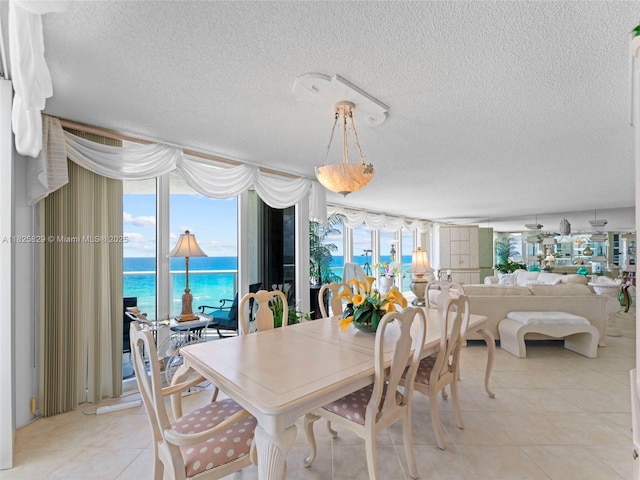 16445 Collins Ave Unit 726, Sunny Isles Beach, FL 33160 - dining area featuring a textured ceiling, a water view, and light tile patterned floors