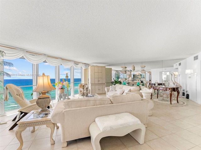 16445 Collins Ave Unit 726, Sunny Isles Beach, FL 33160 - living room with light tile patterned flooring, a textured ceiling, healthy amount of natural light, and a water view