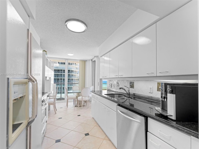 16445 Collins Ave Unit 726, Sunny Isles Beach, FL 33160 - kitchen with stainless steel dishwasher, decorative backsplash, floor to ceiling windows, white cabinetry, and a textured ceiling