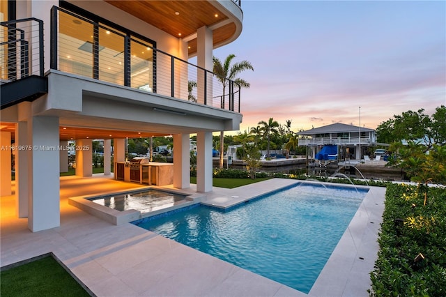 301 Buttonwood Cir # B, Key Largo, FL 33037 - pool at dusk featuring exterior kitchen, a patio area, and an outdoor pool