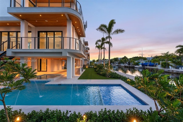 301 Buttonwood Cir # B, Key Largo, FL 33037 - back of property with a balcony, a patio area, stucco siding, an outdoor pool, and a water view