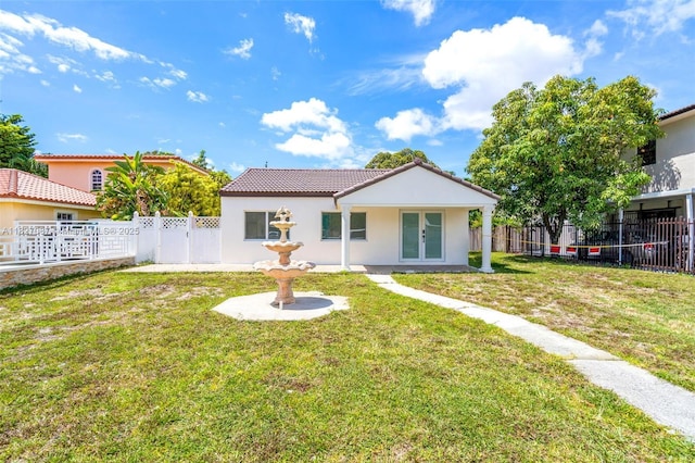 770 SE 5th Pl, Hialeah, FL 33010 - back of house featuring french doors, a fenced backyard, a tiled roof, and stucco siding