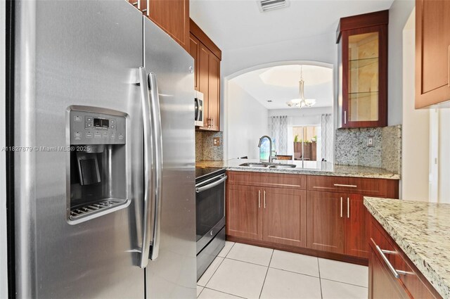 8366 NW 10th St Unit 3B, Miami, FL 33126 - kitchen with appliances with stainless steel finishes, arched walkways, light tile patterned flooring, a chandelier, and tasteful backsplash