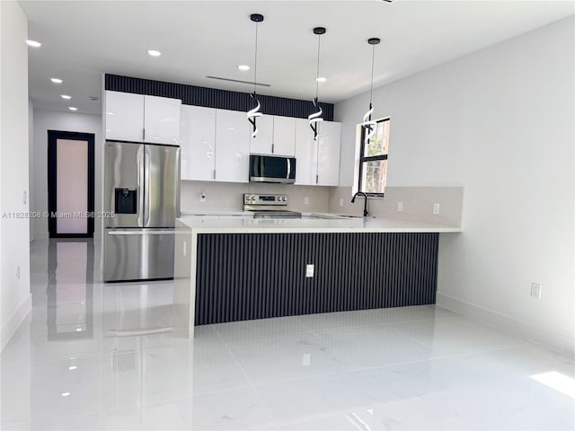 505 W 10th St, Lehigh Acres, FL 33972 - kitchen with stainless steel appliances, white cabinetry, light countertops, a peninsula, and recessed lighting