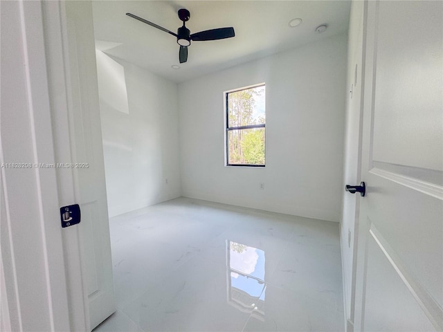 505 W 10th St, Lehigh Acres, FL 33972 - unfurnished bedroom with marble look tile flooring and a ceiling fan