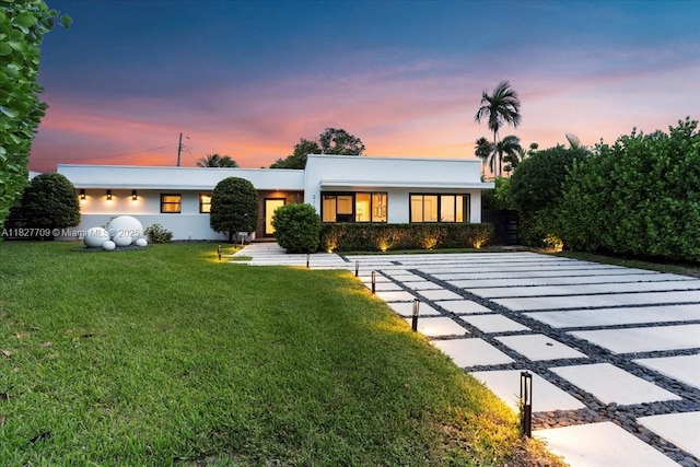 2180 Alamanda Dr, North Miami, FL 33181 - back of property featuring stucco siding and a lawn