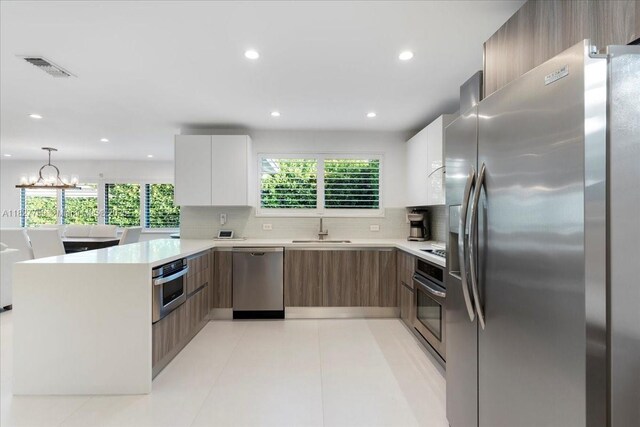 2180 Alamanda Dr, North Miami, FL 33181 - kitchen with stainless steel appliances, modern cabinets, a peninsula, light countertops, and recessed lighting