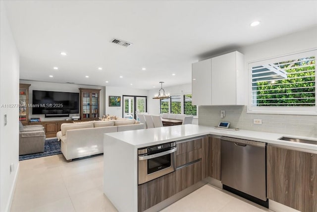 2180 Alamanda Dr, North Miami, FL 33181 - kitchen with appliances with stainless steel finishes, modern cabinets, a peninsula, light countertops, and recessed lighting