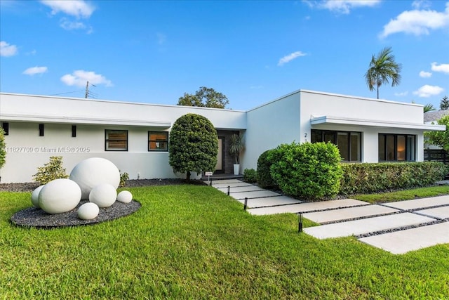 2180 Alamanda Dr, North Miami, FL 33181 - art deco home featuring stucco siding and a front lawn