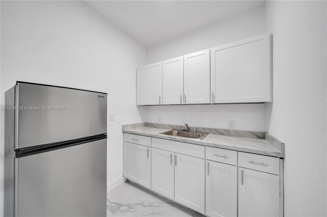 14795 SW 174th St, Miami, FL 33187 - kitchen featuring freestanding refrigerator, light marble finish floors, light countertops, and white cabinetry