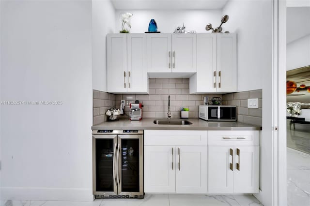 1550 SW 89th Ct, Miami, FL 33174 - kitchen with wine cooler, light marble finish floors, white cabinetry, and tasteful backsplash