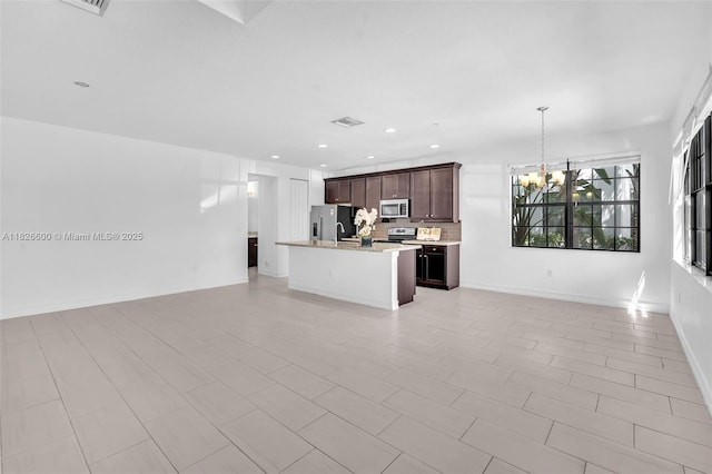 11735 SW 13th Ct, Pembroke Pines, FL 33025 - kitchen with open floor plan, stainless steel appliances, a chandelier, decorative backsplash, and a center island with sink