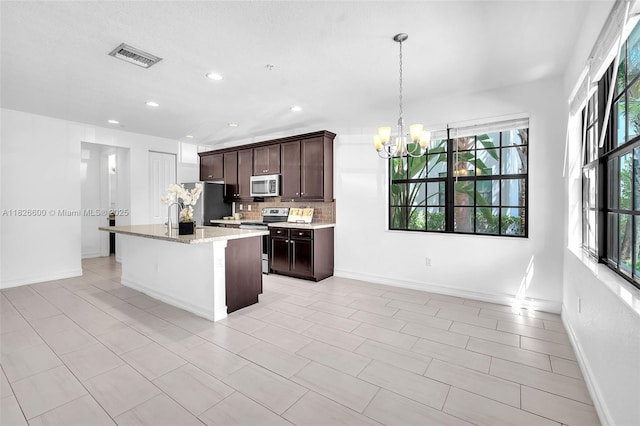 11735 SW 13th Ct, Pembroke Pines, FL 33025 - kitchen with stainless steel appliances, plenty of natural light, a chandelier, decorative backsplash, and recessed lighting