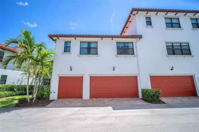11735 SW 13th Ct, Pembroke Pines, FL 33025 - view of front of house with a tile roof, a garage, stucco siding, and decorative driveway