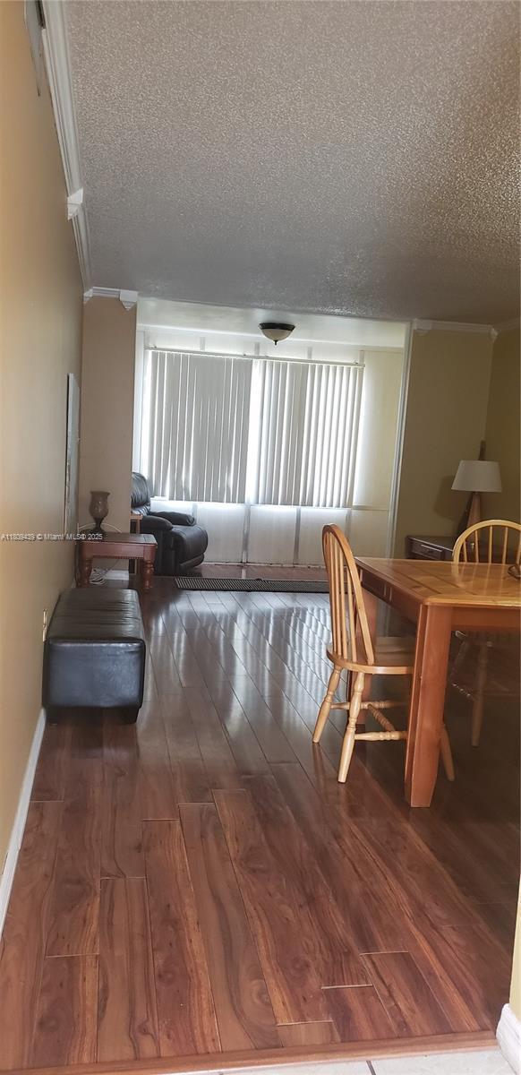 8280 Sunrise Lakes Blvd Unit 105, Sunrise, FL 33322 - dining area featuring a textured ceiling, ornamental molding, hardwood / wood-style floors, and plenty of natural light