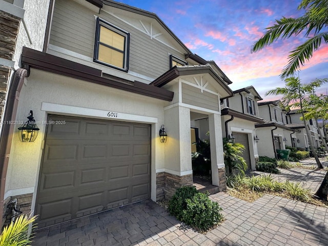 6011 W Paso Fino Pl, Davie, FL 33314 - view of front of house with stone siding, stucco siding, decorative driveway, and an attached garage