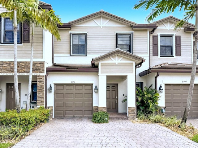 6011 W Paso Fino Pl, Davie, FL 33314 - townhome / multi-family property featuring stone siding, a garage, decorative driveway, and stucco siding