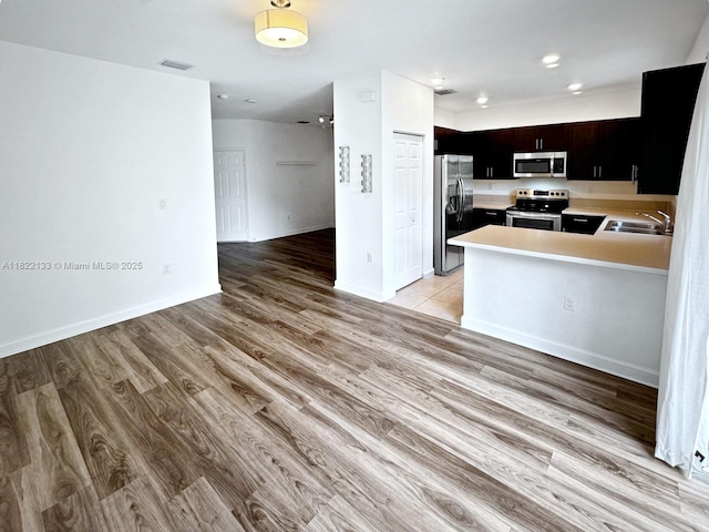 6011 W Paso Fino Pl, Davie, FL 33314 - kitchen featuring stainless steel appliances, open floor plan, light countertops, and light wood-style floors