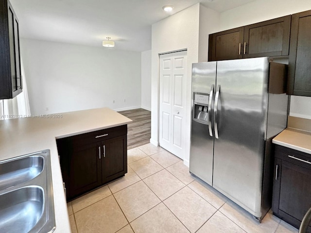 6011 W Paso Fino Pl, Davie, FL 33314 - kitchen with stainless steel fridge with ice dispenser, light countertops, light tile patterned floors, dark brown cabinets, and a peninsula