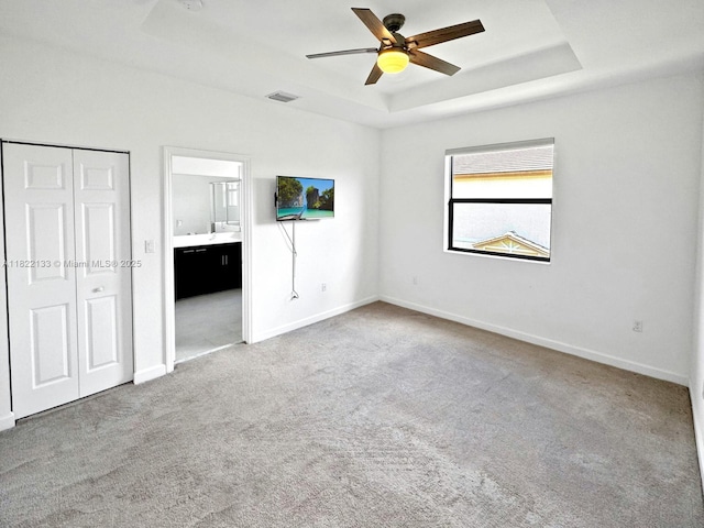 6011 W Paso Fino Pl, Davie, FL 33314 - unfurnished bedroom with a raised ceiling, carpet floors, ensuite bath, a ceiling fan, and a closet