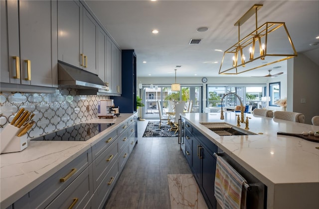 475 Bahia Honda Rd, Key Largo, FL 33037 - kitchen featuring black electric stovetop, under cabinet range hood, recessed lighting, wood finished floors, and backsplash