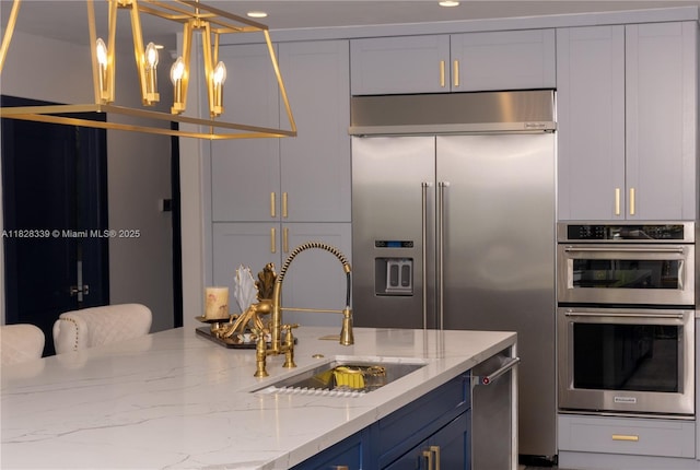 475 Bahia Honda Rd, Key Largo, FL 33037 - kitchen with appliances with stainless steel finishes, light stone counters, a chandelier, and blue cabinets