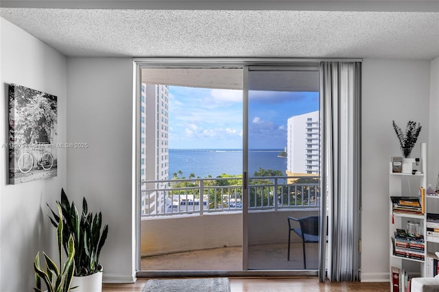 770 Claughton Island Dr Unit 1210, Miami, FL 33131 - interior space featuring multiple windows, floor to ceiling windows, a water view, a textured ceiling, and wood finished floors