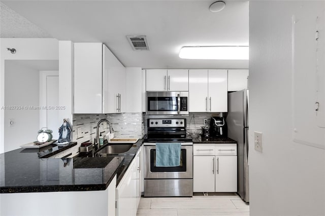 770 Claughton Island Dr Unit 1210, Miami, FL 33131 - kitchen with stainless steel appliances, backsplash, white cabinetry, and dark stone countertops