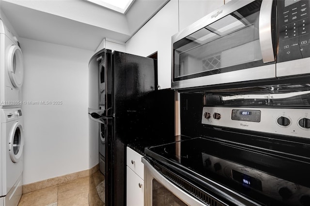 520 Brickell Key Dr Unit A1817, Miami, FL 33131 - kitchen featuring appliances with stainless steel finishes, stacked washing machine and dryer, white cabinetry, and dark countertops