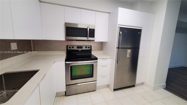 3400 NE 192nd St Unit 510, Aventura, FL 33180 - kitchen with appliances with stainless steel finishes, decorative backsplash, white cabinets, light stone counters, and modern cabinets