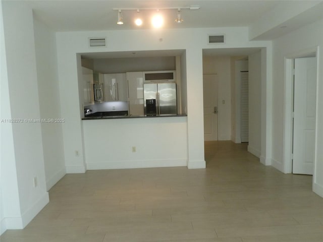 7350 SW 89th St Unit 808S, Miami, FL 33156 - unfurnished living room featuring light wood-type flooring and rail lighting