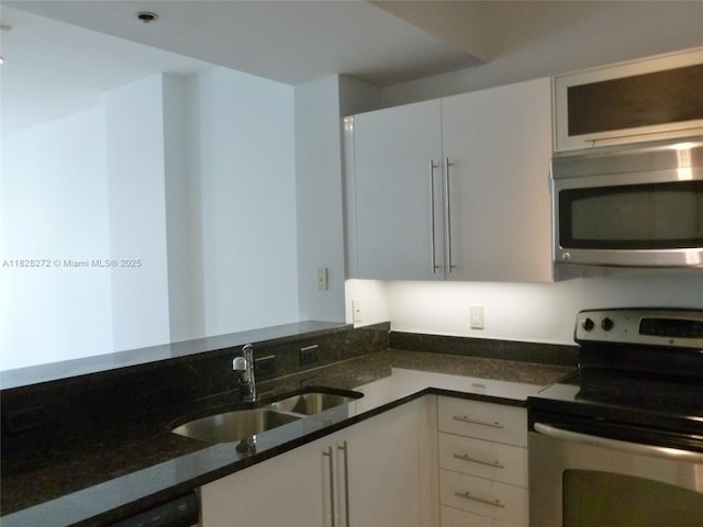 7350 SW 89th St Unit 808S, Miami, FL 33156 - kitchen featuring stainless steel appliances, dark stone countertops, and white cabinets