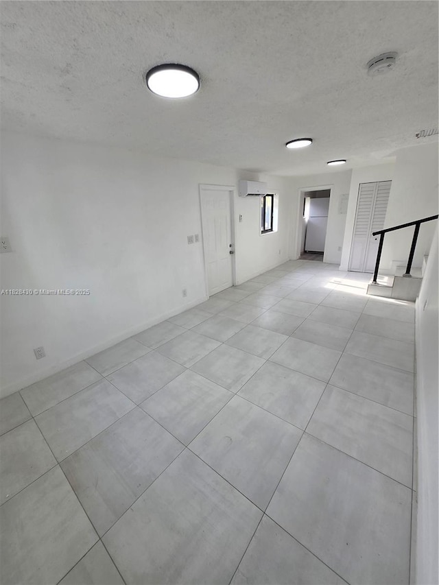 335 W 60th St, Hialeah, FL 33012 - empty room with a textured ceiling, light tile patterned flooring, a smoke detector, and a wall mounted air conditioner