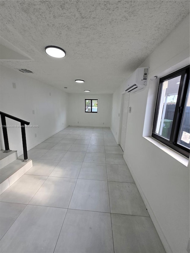 335 W 60th St, Hialeah, FL 33012 - spare room with a wall mounted air conditioner, a textured ceiling, light tile patterned flooring, and stairway