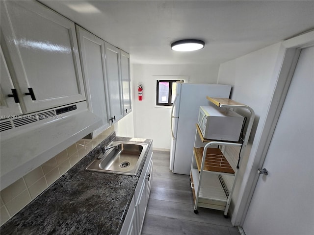 335 W 60th St, Hialeah, FL 33012 - kitchen with backsplash, wood finished floors, and white cabinetry
