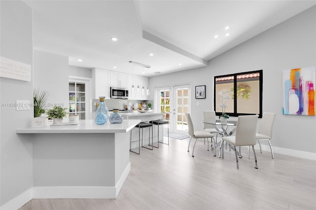 220 SW 113th Ter, Pembroke Pines, FL 33025 - kitchen with stainless steel microwave, light countertops, white cabinetry, a breakfast bar area, and decorative backsplash