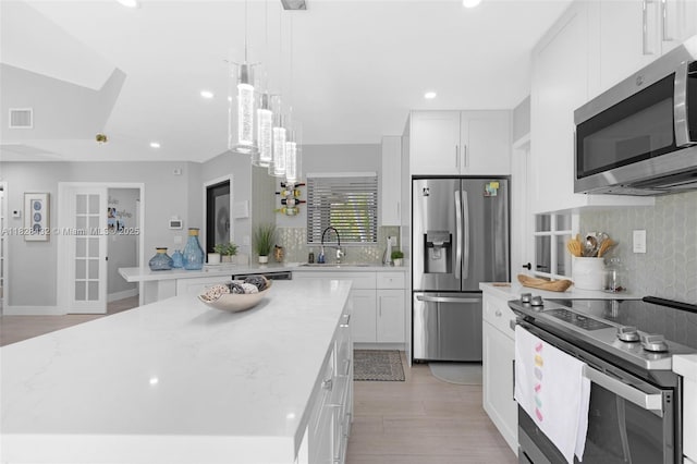 220 SW 113th Ter, Pembroke Pines, FL 33025 - kitchen featuring appliances with stainless steel finishes, backsplash, white cabinetry, recessed lighting, and light wood-style flooring