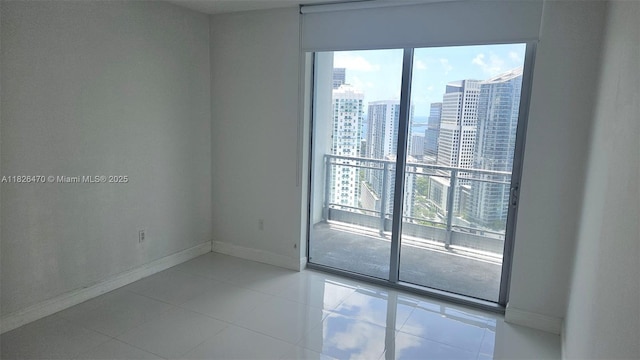 90 SW 3rd St Unit 4110, Miami, FL 33130 - tiled spare room featuring baseboards and a city view