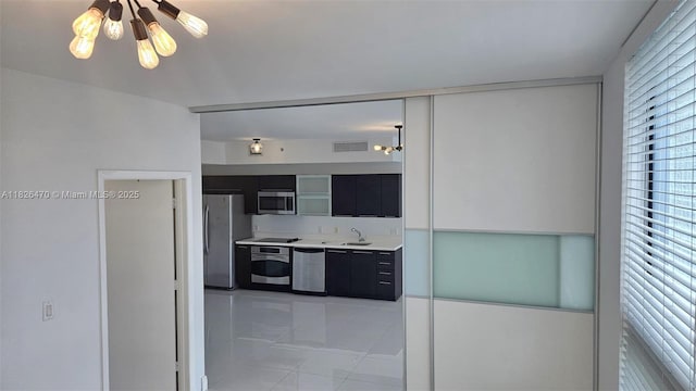 90 SW 3rd St Unit 4110, Miami, FL 33130 - kitchen with dark cabinetry, stainless steel appliances, light tile patterned flooring, light countertops, and modern cabinets