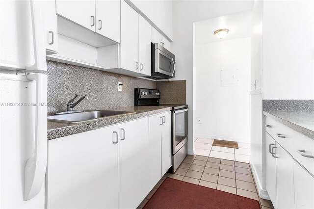 7400 W 20th Ave Unit 315, Hialeah, FL 33016 - kitchen with stainless steel appliances, white cabinetry, decorative backsplash, and tile patterned flooring