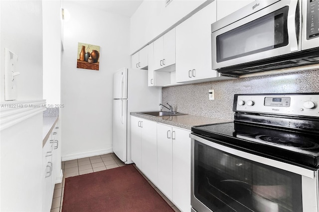 7400 W 20th Ave Unit 315, Hialeah, FL 33016 - kitchen with stainless steel appliances, tile patterned flooring, white cabinetry, backsplash, and light countertops