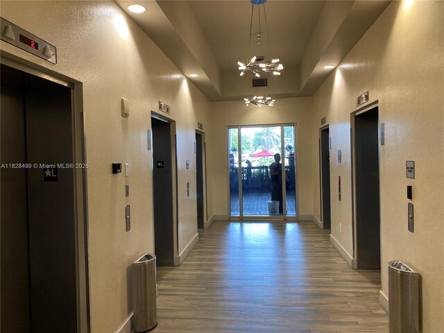 1750 N Bayshore Dr Unit 2707, Miami, FL 33132 - hallway featuring a chandelier, light wood-type flooring, elevator, recessed lighting, and a raised ceiling