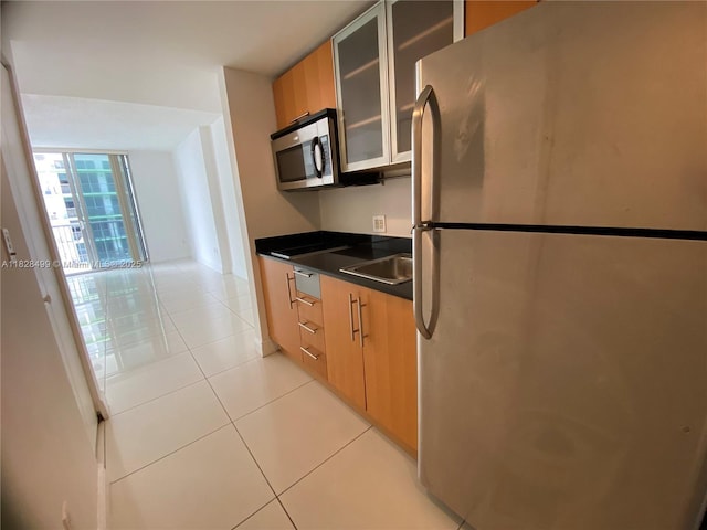 1750 N Bayshore Dr Unit 2707, Miami, FL 33132 - kitchen featuring appliances with stainless steel finishes, light tile patterned floors, glass insert cabinets, dark countertops, and modern cabinets
