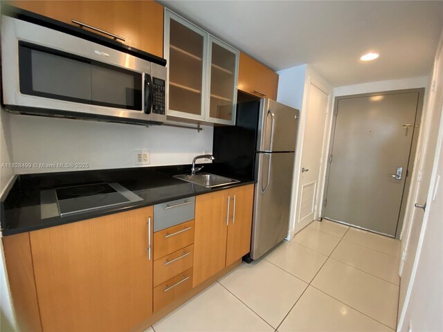 1750 N Bayshore Dr Unit 2707, Miami, FL 33132 - kitchen with appliances with stainless steel finishes, light tile patterned flooring, glass insert cabinets, dark countertops, and modern cabinets
