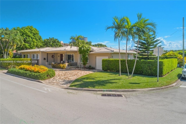424 89th St, Surfside, FL 33154 - ranch-style house featuring a front yard, stucco siding, a garage, and driveway