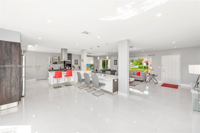 424 89th St, Surfside, FL 33154 - kitchen with island exhaust hood, open floor plan, recessed lighting, a large island, and a breakfast bar area