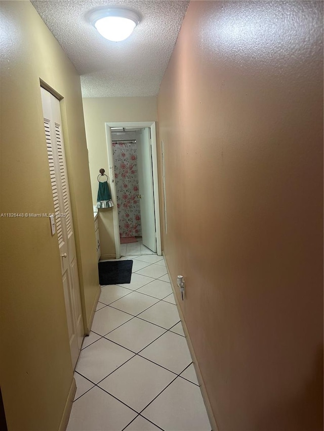 1900 W 54th St Unit 113, Hialeah, FL 33012 - hallway featuring a textured ceiling and light tile patterned flooring